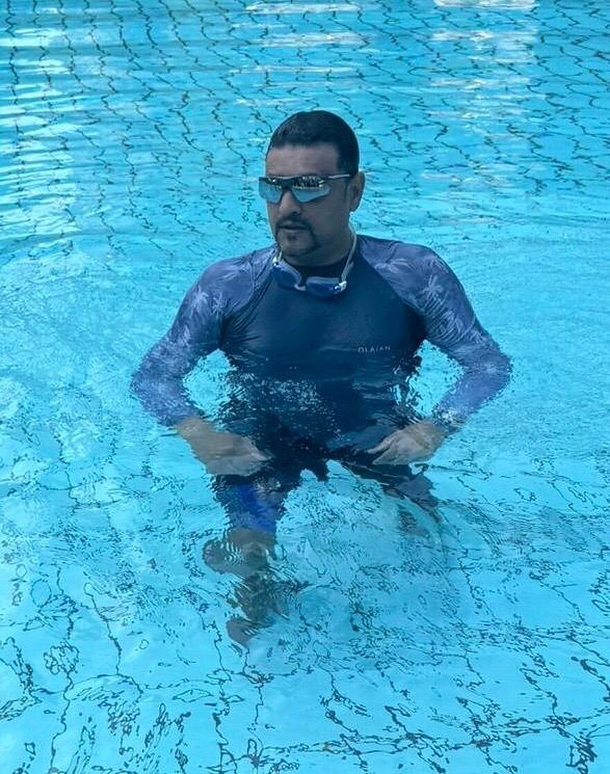 Coach U.K. Singh standing in a swimming pool in Singapore